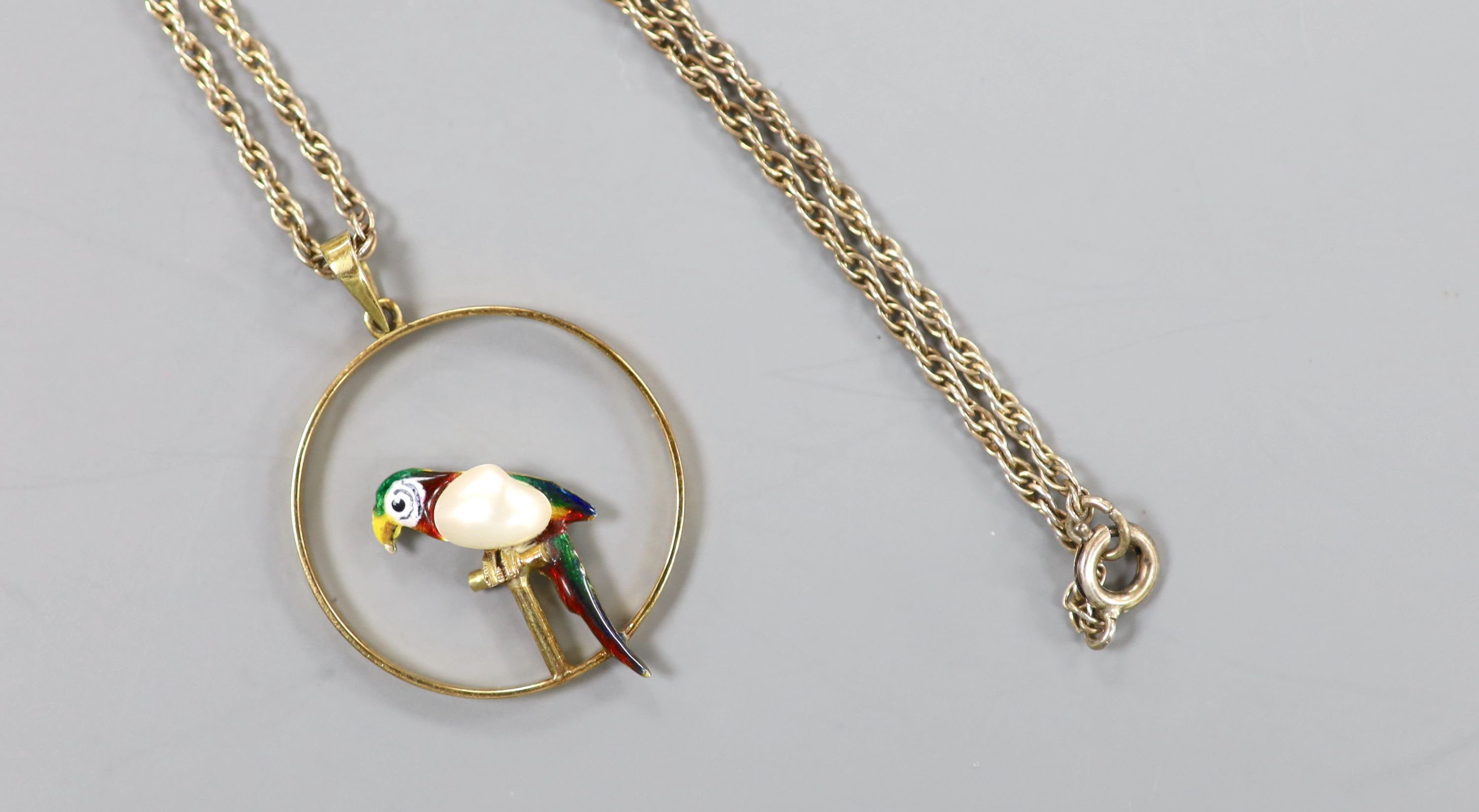 An early 20th century 15ct, enamel and baroque pearl set open work circular pendant, 22mm, gross 2.4 grams, on a later sterling chain.